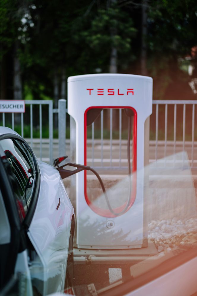 Electric vehicle drawing power at a public charging bay